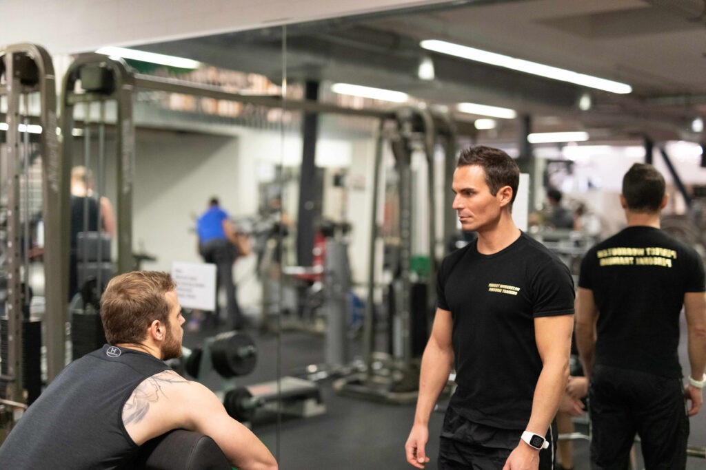 Personal Trainer unterstützt beim intensiven Muskelaufbau mit gezielten Intensitätstechniken im Fitnessstudio in Zürich.