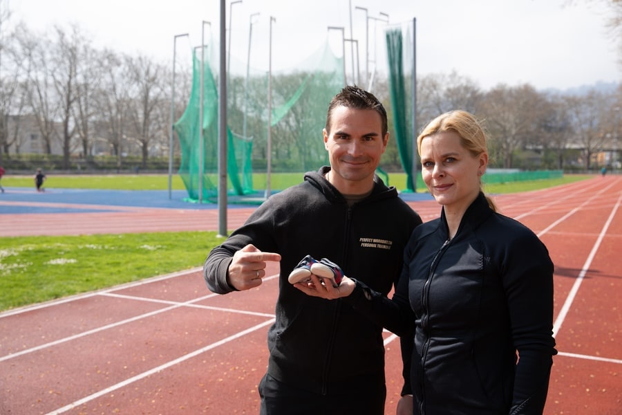 Personal Trainer Keren Lopata motiviert eine Klientin bei einem Outdoor-Training auf der Laufbahn